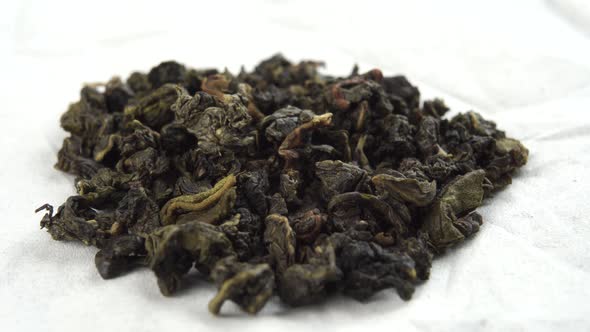 Dried fermented gunpowder green tea leaves in white paper wrapper