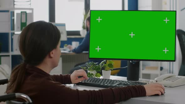 Immobilized Woman Working on Desktop Computer with Green Mockup Screen