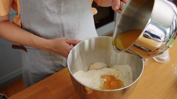 Woman Making Dough and Pouring Melt Butter to Bowl