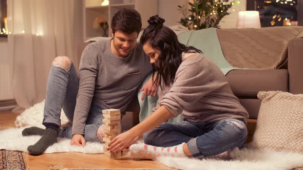 Happy Couple Playing Block-stacking Game at Home