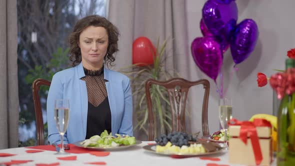 Portrait of Frustrated Crying Caucasian Woman Sitting at Valentine's Dinner Table Alone