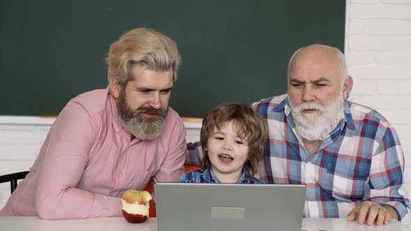 Home Education Concept. Learning Online. Father, Grandfather and Son Studies at Home and Does School