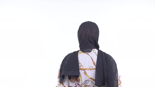 Rear View of Young African Muslim Woman Touching Something