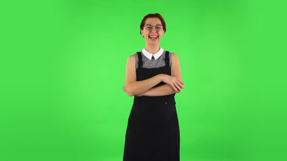 Funny Girl in Round Glasses Communicates with Someone in a Friendly Manner. Green Screen