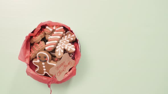 Traditional home made gingerbread cookies as food gifts on blue background with Christmas light.