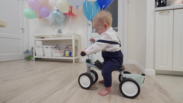 Kid on Baby Bicycle Balance Bike for Toddlers with Colorful Balloons 1 Year Old Baby Boy Celebrating