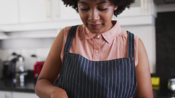 Portrait of african american woman chopping vegetables in the kitchen at home