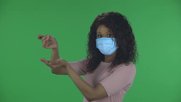 Portrait of Beautiful African American Young Woman in Medical Protective Face Mask Pours Medicine