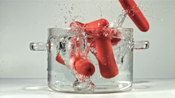 Sausages Fall a Clear Pot of Water with Splashes