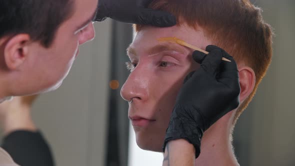 Brow Master Applying Wax on Top of the Brow of His Male Client