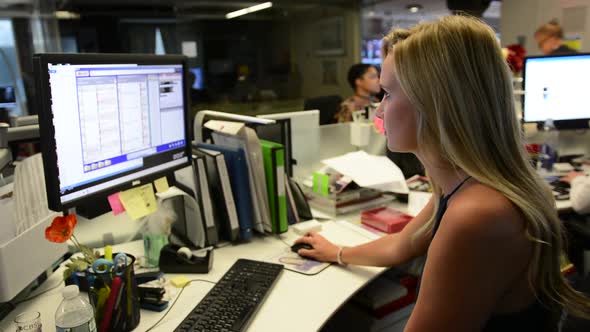 Pretty blond woman working at desk on computer