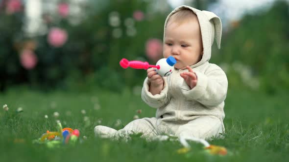 A Cheerful Baby Girl is Playing on the Grass