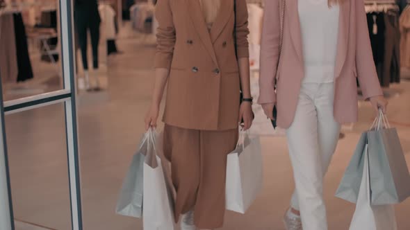 Happy Female Friends Walking out of Clothes Shop