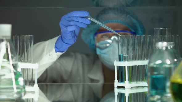 Scientist Dripping Chemical Agent in Tube With Blue Liquid Conducting Experiment