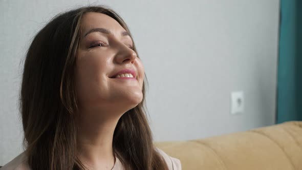 Happy Woman Enjoying the Wind From the Fan