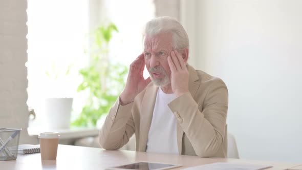 Old Man Having Headache While Sitting at Work