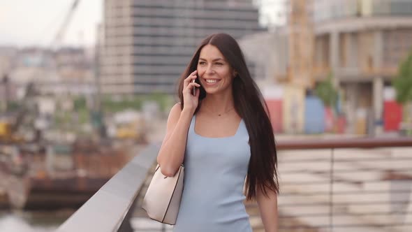 Pretty young woman using a mobile phone while walking on the street