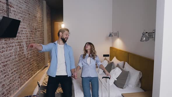 Young Couple in Love which Holding their Hands and Falling Down on their Bed in Hotel Room