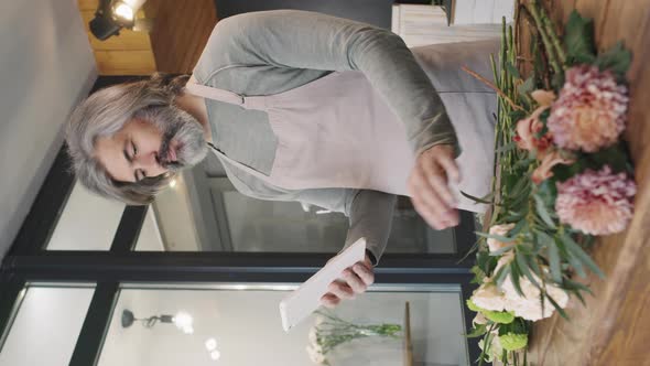 Male Florist With Tablet In Flower Shop