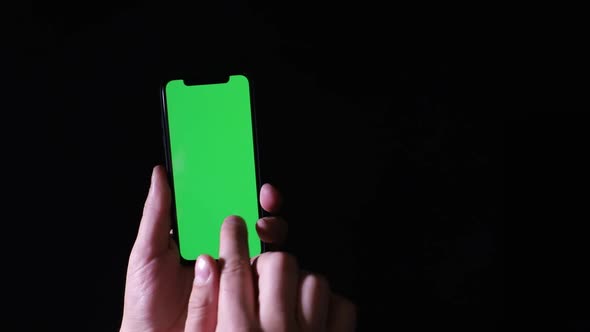 Smartphone with chromakey screen on black background. Place for dvertising on a smartphone
