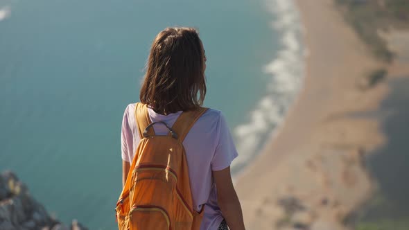 Rear View Happy Girl Stands on Edge of High Cliff Enjoying Beautiful Seascape of Aegean Coastline