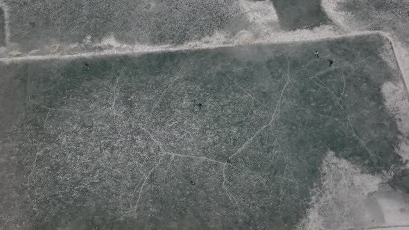 Aerial Birds Eye View Over  Ice Hockey Players On Frozen Khalti Lake At Ghizer Valley. Rotating Shot