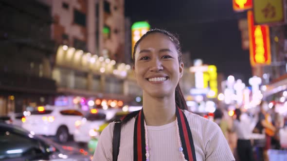 a beautiful woman taking off a medical mask and smiling on the background of a city at night.