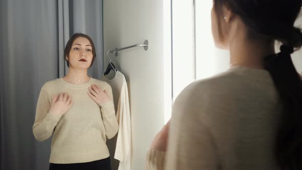 Beautiful Woman Measures the Clothes in a Fitting Room