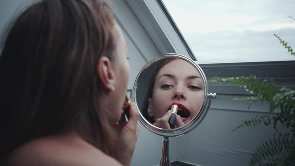 Young Woman Applying Lipstick