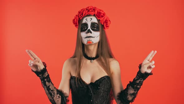 Day of Dead Female with Skull Makeup Taking Imaginary Pistols Out of Holster Smiling and Posing with