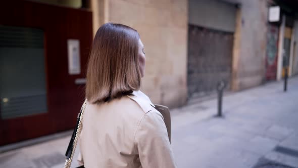 Side View of Woman Walking Alone in European Street