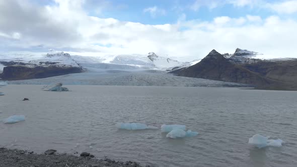 Slow Aerial Dolly Shot of a Glacial Lagoon with Floating Icebergs.