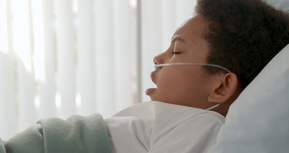 Sick African Kid Having Fever and Sweating Lying in Hospital Bed