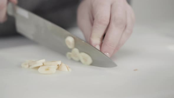 Curring vegetables on a white cutting board to cook vegetarian white bean soup.