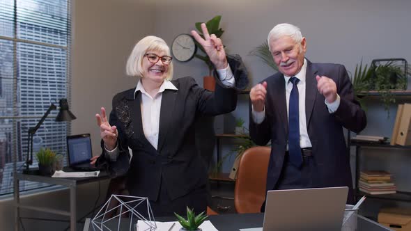 Two Joyful Collegues in Formal Suits Dancing Victory Dance Celebrating Success of Business Project