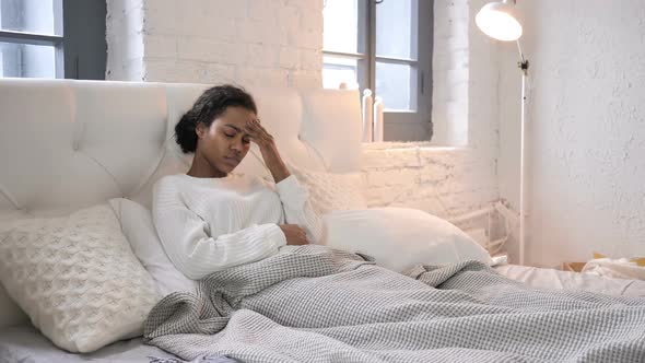 Young African Girl with Headache Relaxing in Bed