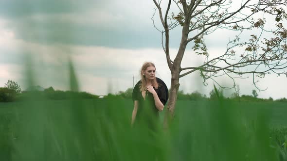 Portrait Of Pretty Blonde. Girl Stands Under Tree.