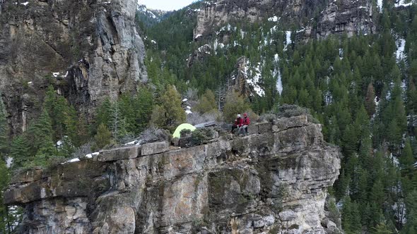 View of campsite on top of cliff flying backwards for wider view