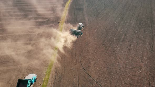 Aerial View of Tractor with Mounted Seeder Performing Direct Seeding of Crops on Plowed Agricultural