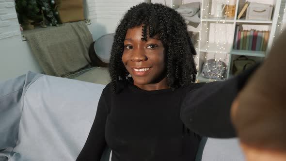 Attractive Young Black Woman with Curly Hair Looks Smiling