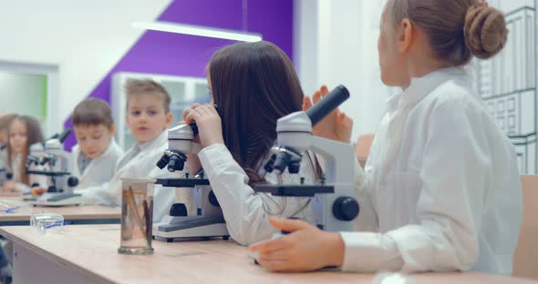 Boys and Girls Looking Through Microscope in Laboratory at School