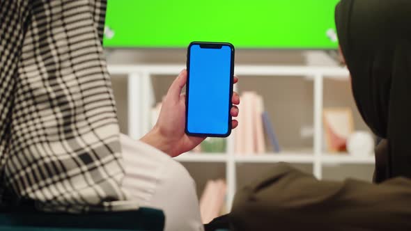 Middle Eastern Family Using Phone with Chroma Key Closeup Watching Video or Film