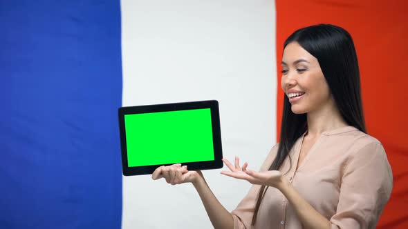 Girl Holding Tablet With Green Screen, France Flag on Background, Migration