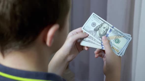 Successful Teenager Counts a Stack of 100Dollar Bills in Room