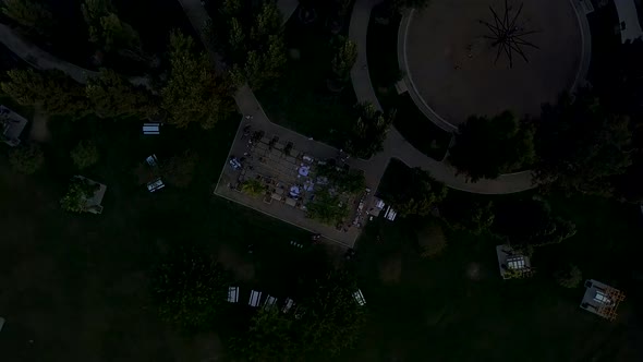 Aerial view of a beautiful green park with a wedding reception even going on. Lots of paths, shapes,