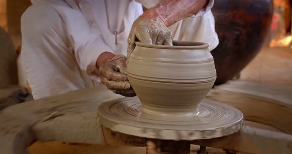 Skilled Hands of Potter Shaping the Clay on Potter Wheel and Sculpting Clay Pot Jar. Shilpagram