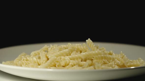 SLOW MOTION: Cooked Spiral Pasta Fall Into Full Plate