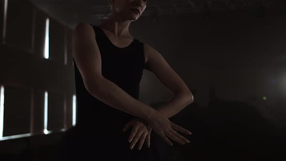 Closeup of Ballet Dancer As She Practices Exercises on Dark Stage or Studio