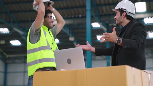 Two Factory Worker Celebrate Success Together in the Factory