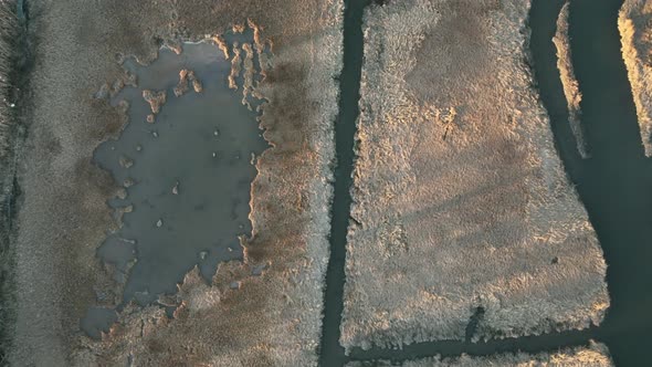 An aerial view directly over a dry, brown salt marsh on Long Island, NY. Taken on a sunny day as var